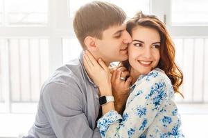 Real love. Beautiful young couple bonding and smiling while sitting in the bedroom photo