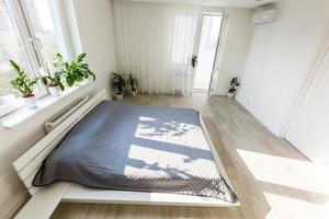 Simple exclusive white bedroom with wooden parquet photo