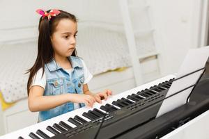 Happy Small Girl with the Piano Keyboard photo