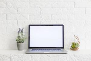 computadora portátil pantalla blanca en blanco en la vista frontal de la mesa de trabajo foto