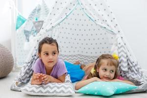 concepto de infancia e higiene - niñas felices jugando en una tienda de campaña para niños foto