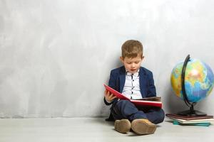 Happy curious kid little boy genius on gray background photo