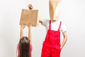 Delivery guy holding a paper bag and a clipboard isolated on white background photo