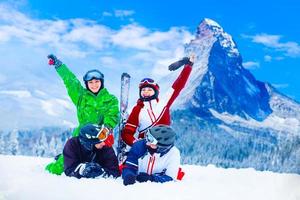 Skiing family enjoying winter vacation on snow in sunny cold day in mountains and fun. Switzerland, Alps. Composite photo. photo