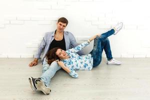 Happy young couple lying on the floor of new house and choosing color from palette photo