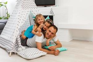 Dad is her best friend. Father and daughter looking at each other and smiling while lying on the floor in bedroom photo