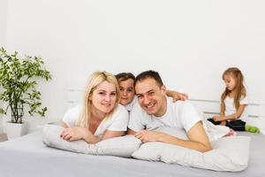 Young family resting together in parent's bed photo