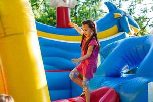 un niño alegre juega en un castillo inflable foto