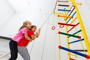 foto de una atractiva atleta de crossfit escalando una cuerda en el gimnasio. guapa chica cuerda escalar en el box de crossfit motivación positividad salud concentración agilidad vida activa batalla cuerda