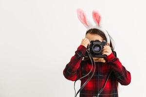 Surprised little girl wearing bunny ears, lying on light wooden floor on Easter Holiday. photo