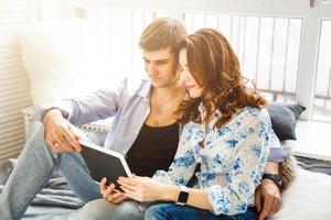 Happy young couple doing shopping on internet photo