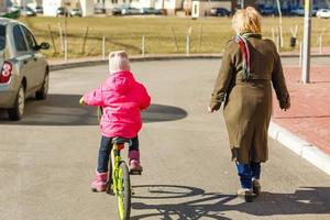 little girl riding bicycle in city park. photo