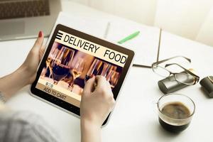 Hipster woman hands holding digital tablet with app delivery food wine screen photo