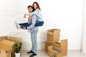 Smiling couple leaning on boxes in new home photo