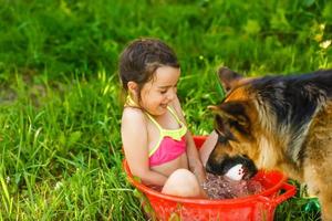 little girl sits in basin with water. Hot summer day photo