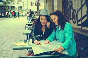 two women sitting at a table on the street photo