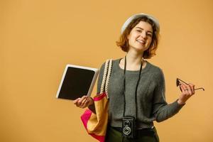 Youth and technology. Colorful studio portrait of young attractive brunette woman using tablet computer against photo