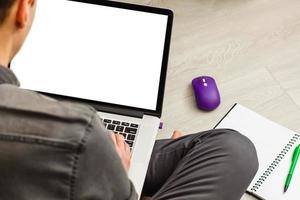 hombre usando, trabajando en una computadora portátil con pantalla en blanco en la sala de estar de casa foto