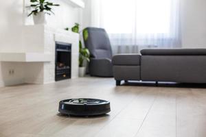 Robotic vacuum cleaner on laminate wood floor in living room photo