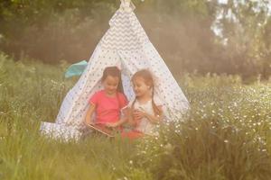 dos niñas juegan cerca de la tienda wigwam foto