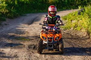 Little girl riding ATV quad bike in race track photo
