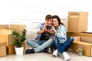 pareja sonriente apoyándose en cajas en un nuevo hogar foto
