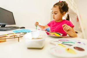 Cut girl painting in at her home. Selective focus and small depth of field. photo