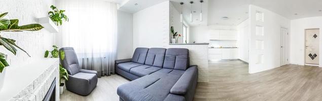 Panoramic view from kitchenette to open living room in modern designed apartment photo