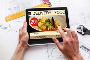 Hipster man hands holding digital tablet with app delivery food screen photo