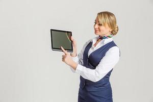 Charming Stewardess Dressed In Blue Uniform with empty blank in hands photo