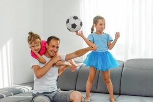 A family of fans watching a football match on TV at home photo