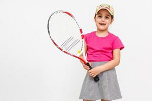 linda niña con raqueta de tenis sobre fondo blanco. foto