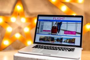 Close-up top view of man working on laptop with tickets flights web. all screen graphics are made up. photo