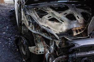 coche quemado. prender fuego a los coches en el estacionamiento. guerras de bandidos, la destrucción de la máquina de fuego después del cóctel molotov. máquina de fuego deformada. consecuencias del accidente automovilístico. dañado por un incendio foto