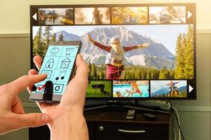 Man watching TV in living room with remote in the hand photo