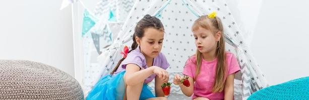 two little girls eating strawberries photo