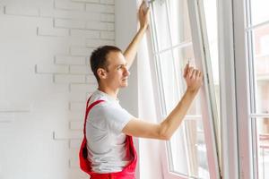 Construction worker installing new window in house photo