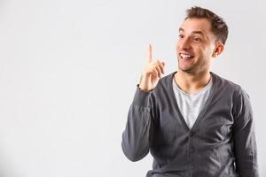 Young man presenting your product, isolated over a white background photo