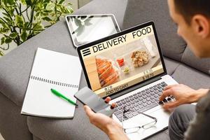 man using smartphone in cafe holding phone with app delivery food screen photo