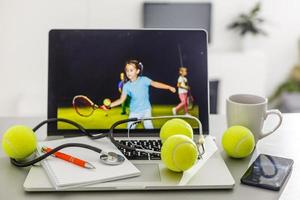 Sports tennis player with racket in blue costume. Woman atlete. Laptop on the table with design for bookmaker advertising photo