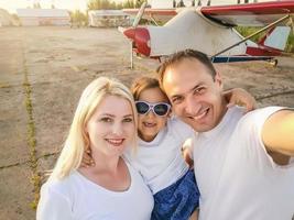 familia feliz pasando un buen rato juntos en la playa, tomando selfie foto