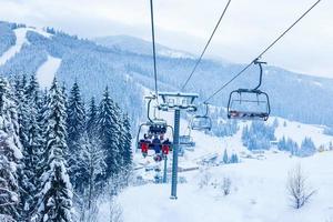 Skiers on chairlift at ski resort photo