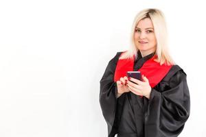 emocionada feliz estudiante graduada está de pie en el manto, sonriendo y mirando a la cámara foto