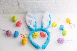 huevos de pascua de colores y orejas de conejo en casa el día de pascua. celebrando la pascua en primavera. pintando huevos foto