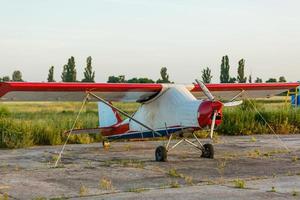 field with plane flying over it photo