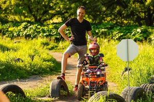 padre e hija jugando en la carretera durante el día. conducen en quad en el parque. gente divirtiéndose en la naturaleza. concepto de familia amistosa. foto