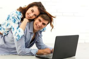 pareja comprando en línea junto con una computadora portátil en una computadora de escritorio en casa foto