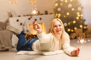 mujer emocionada en navidad acostada en un sofá en la sala de estar en casa foto