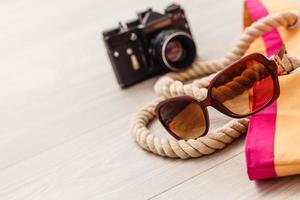 Voyage concept - set of woman stuff on wooden background. photo