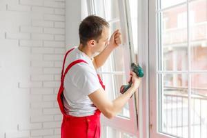 Construction worker installing new window in house photo